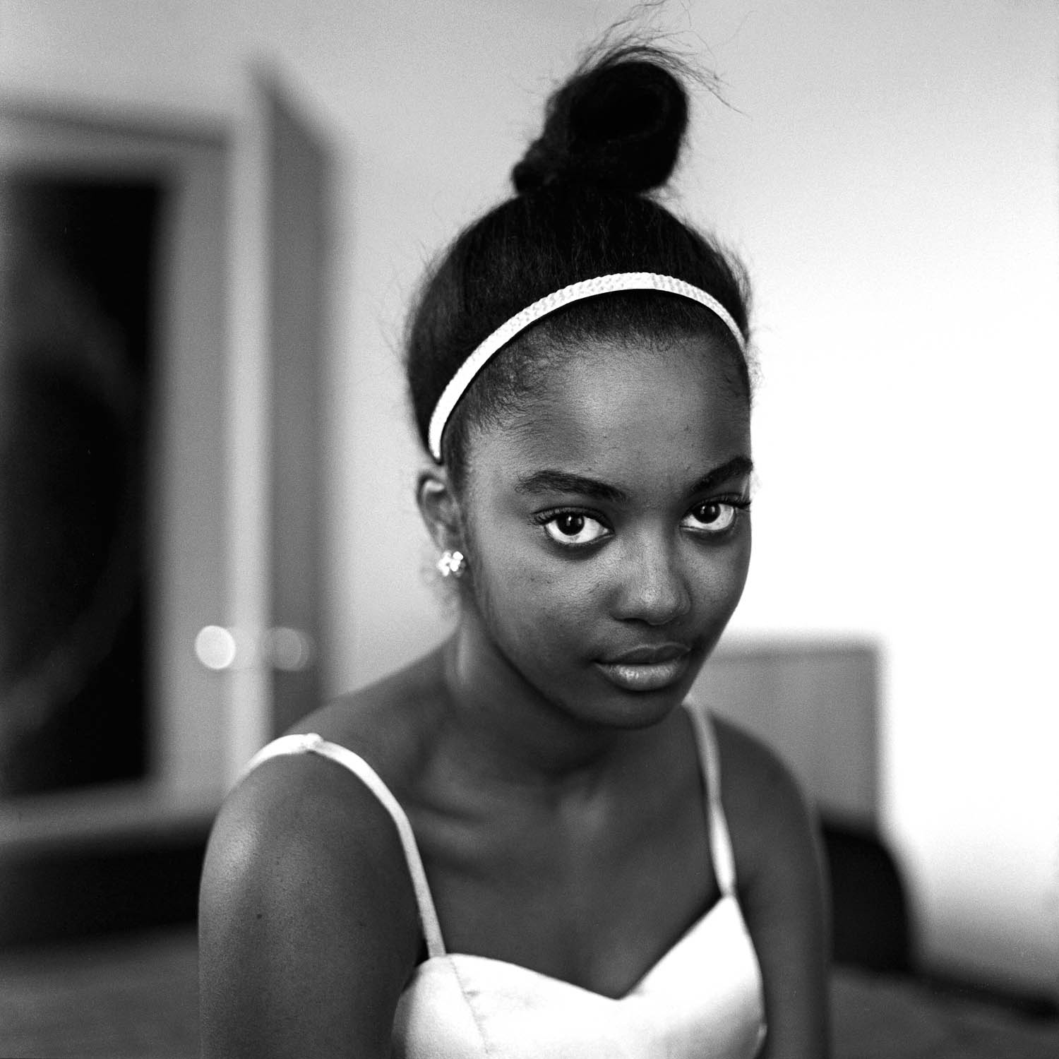 Black and white film portrait of a girl in her bedroom. Photographed with a Hasselblad 500c