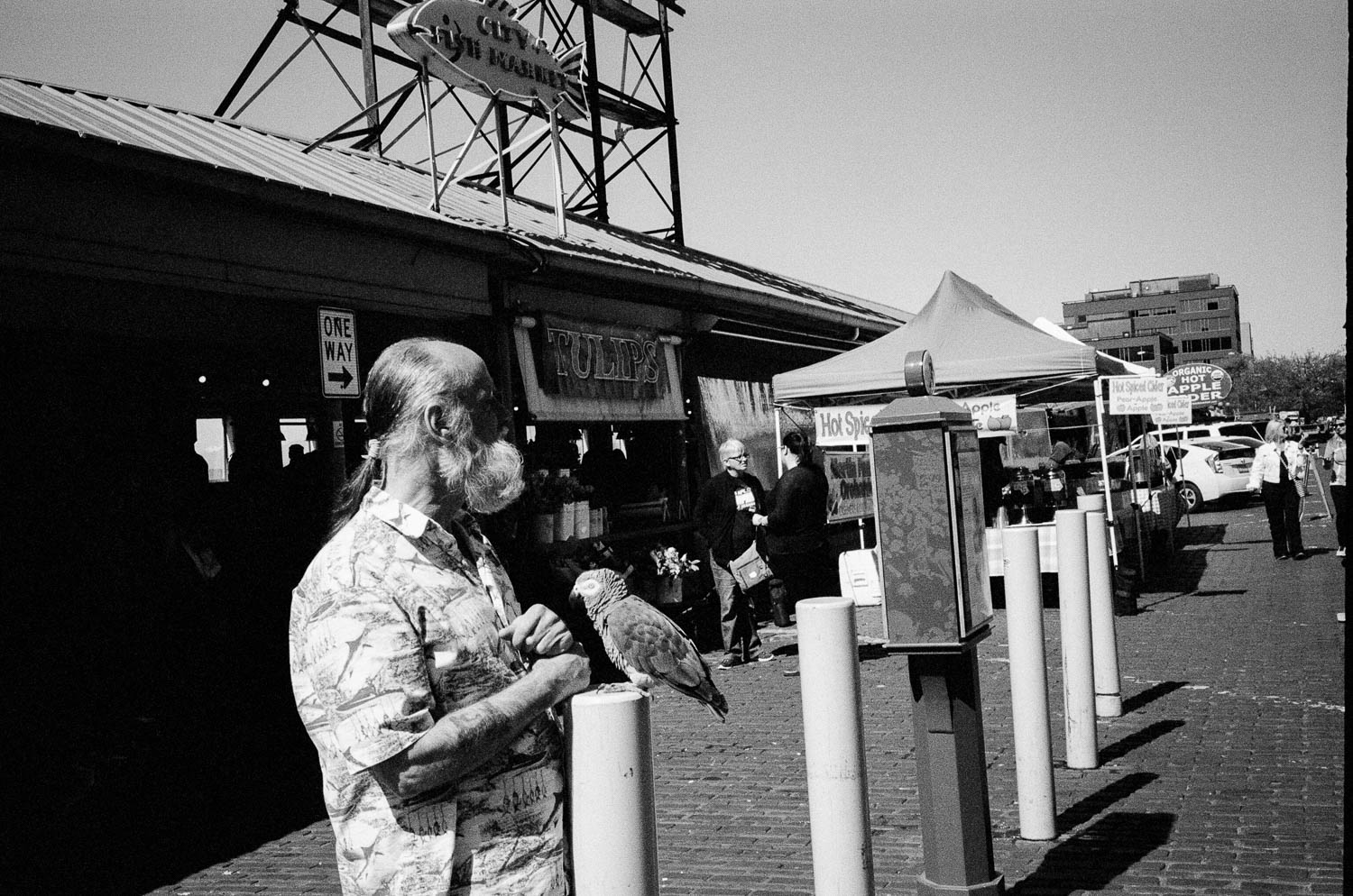 A man with a parrot in front of Pike Place Market in Seattle