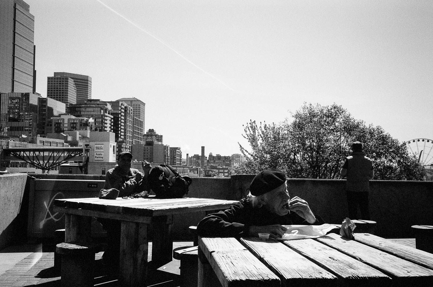 A man in a beret eating a sandwich in Seattle