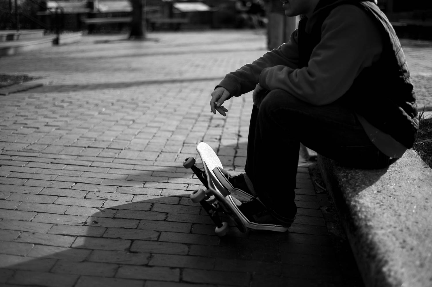 A black and white photo of a skateboarder smoking a cigarette