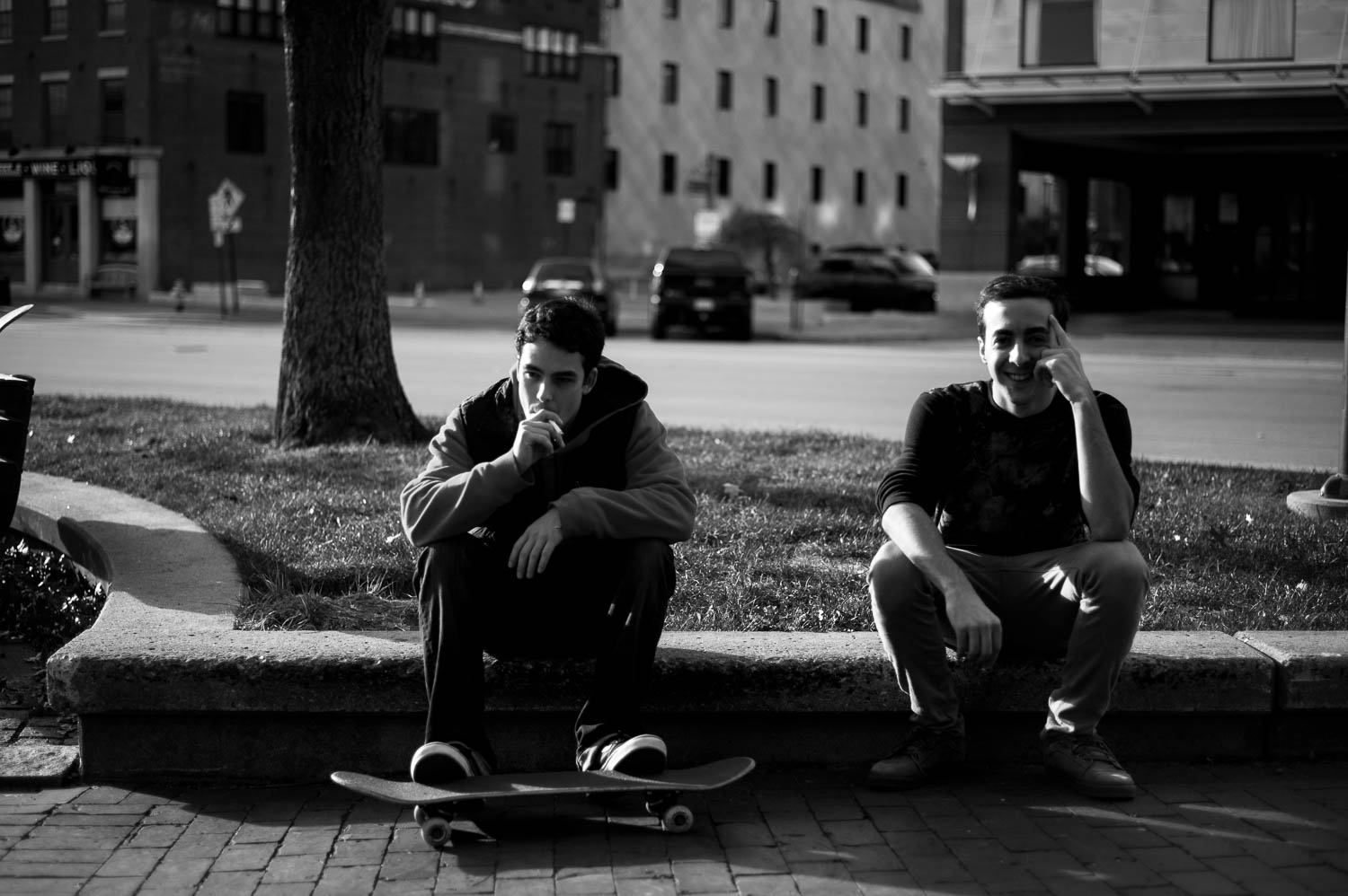 Two skateboarders hanging out and smoking cigarettes