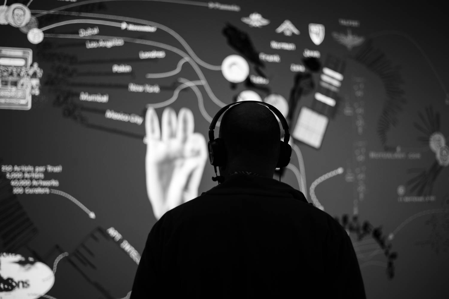 A man wearing headphones and looking at an animated display at ICA Boston