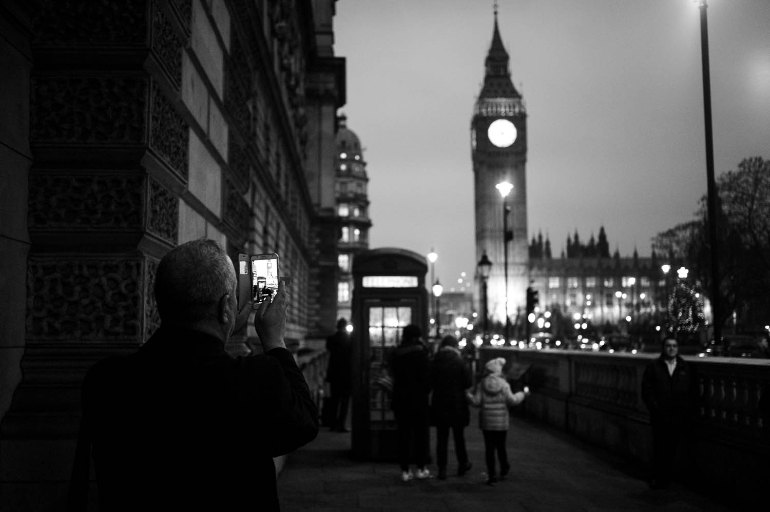 A man photographs Elizabeth Tower with his cell phone in London