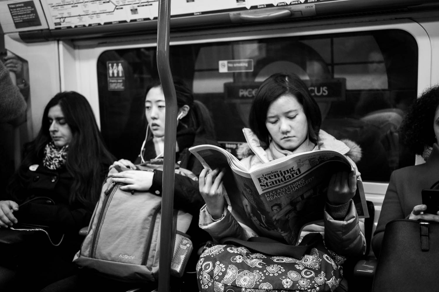 A woman reads the London Evening Standard on the London tube.