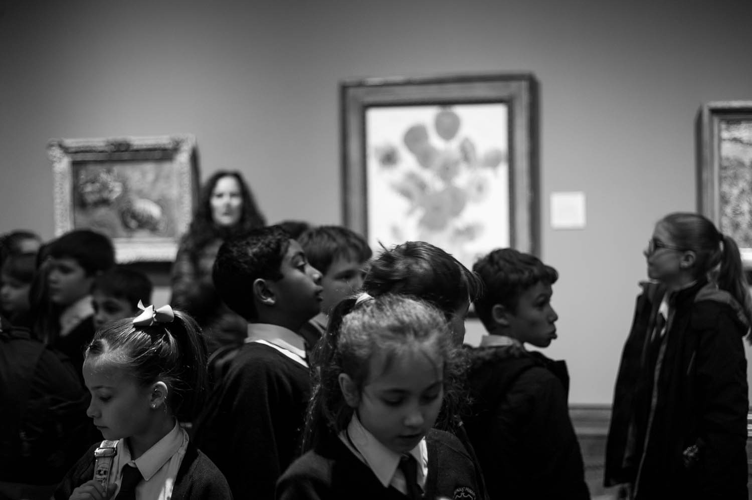School children gathering around Van Gogh's Sunflowers in London.