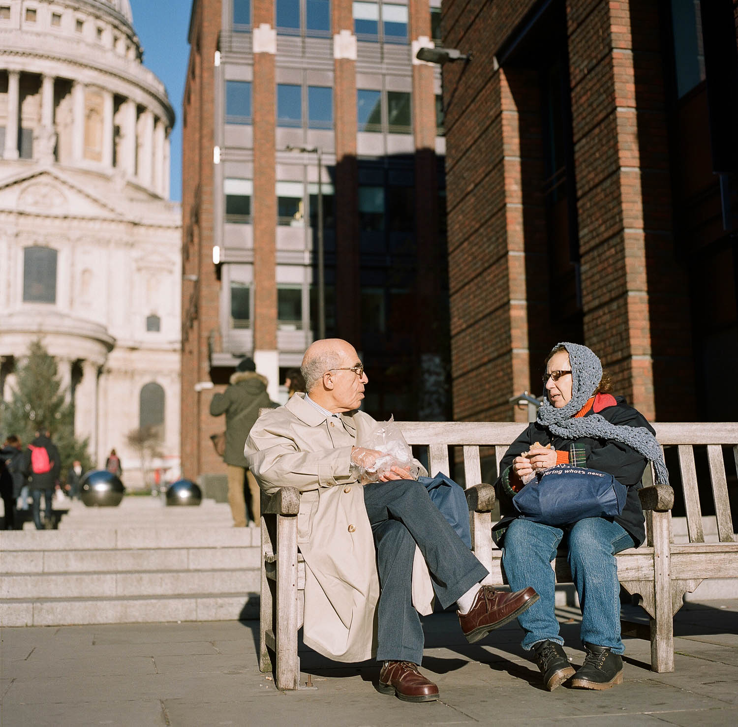 A couple sitting on a bench in front of St. Paul's Cathedral