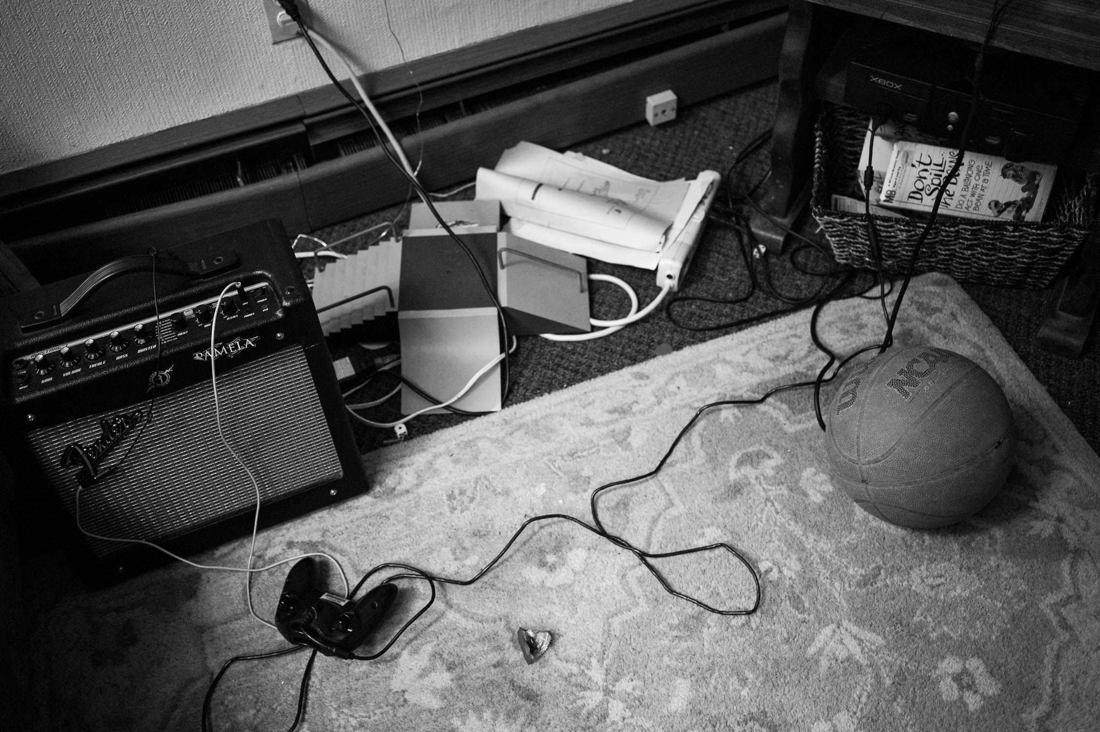 A practice amp, xbox controller, and tech deck skate park on the floor of Avenue D.I.Y.