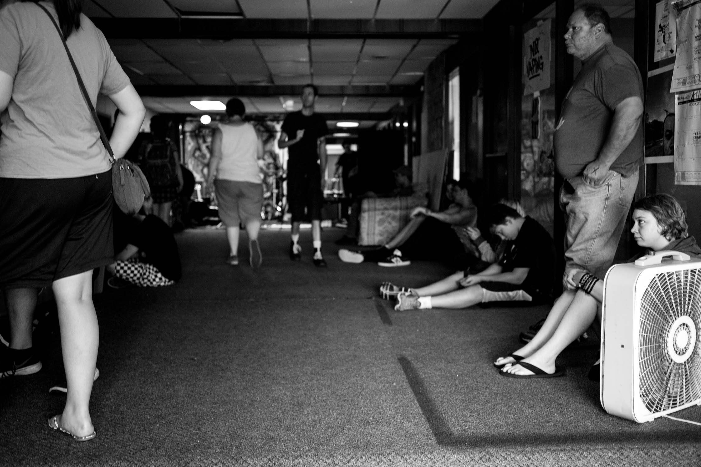 Show goers sitting against either wall before the show starts at Avenue DIY