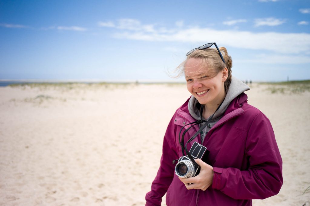 Amanda Vogler holding a Hasselblad 500C on the beach for NEWLK in Nantucket