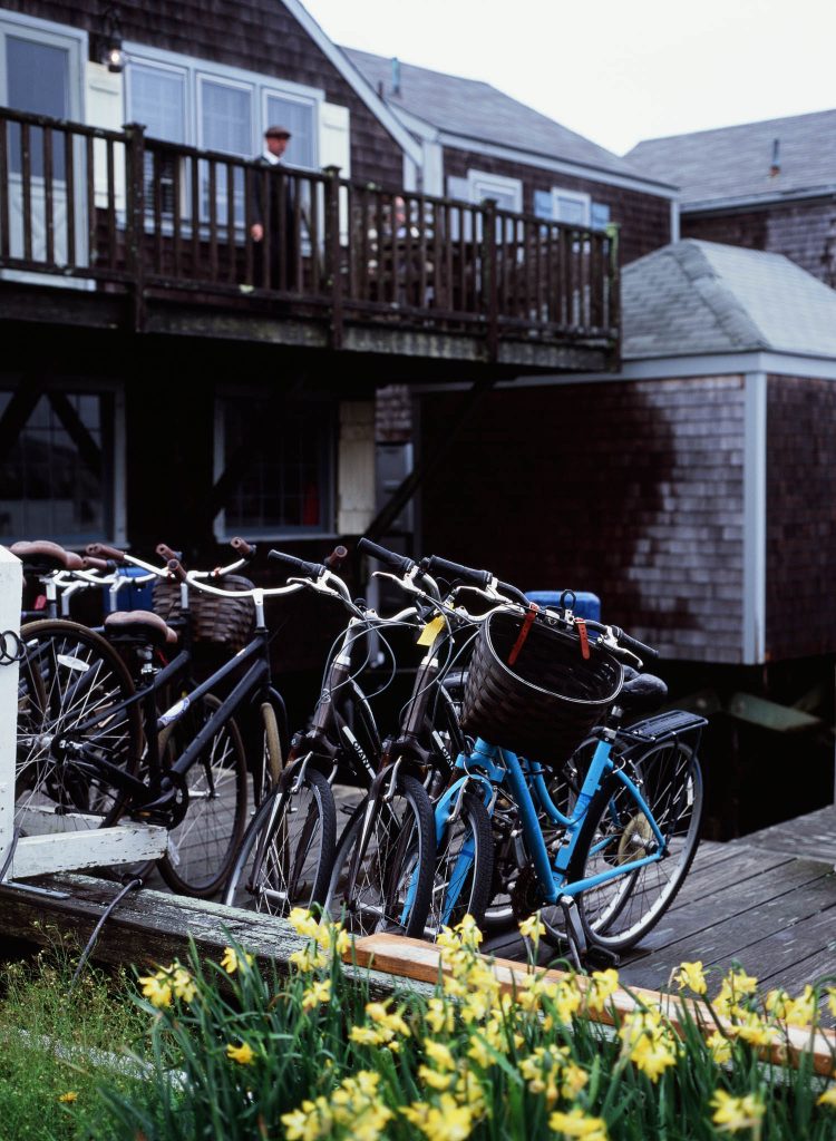 A man overlooking a row of bicycles from a balcony in Nantucket