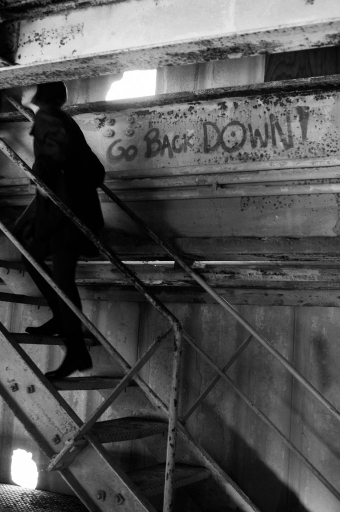 Michele climbing stairs in an abandoned building in Savannah